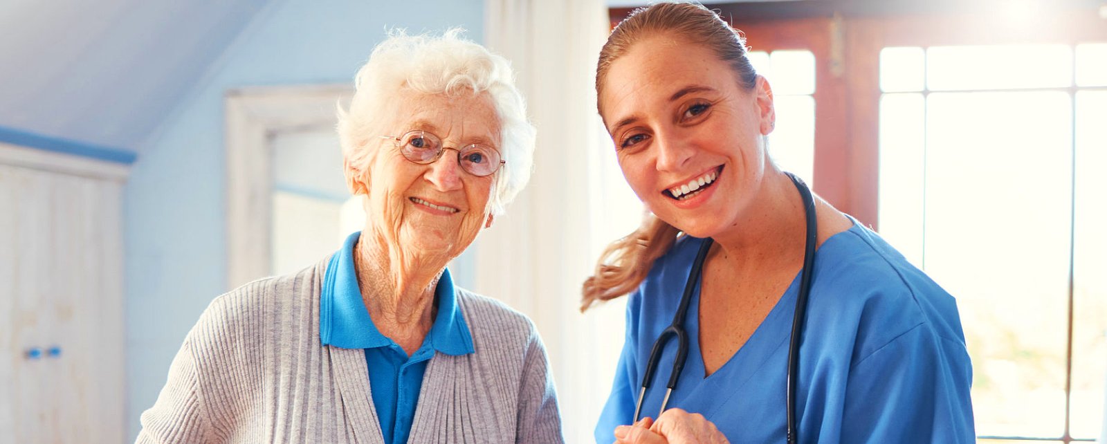 caregiver smiling with her elderly patient